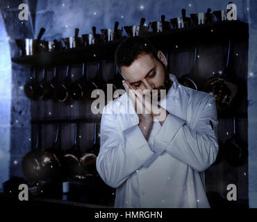 Young Chef sleeping in the kitchen at night. Stock Photo