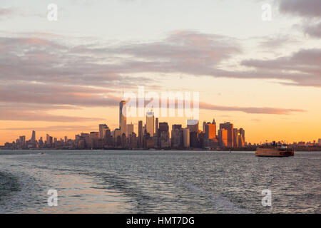 Manhattan island at dawn photographed from the Staten island Ferry, New York City, United States of America. Stock Photo