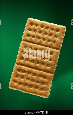 one gold cracker isolated on green background Stock Photo