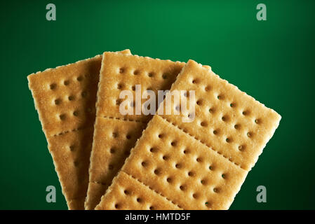 three gold fresh crackers isolated on green background Stock Photo