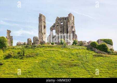 View of the the hilltop ruins of Corfe Castle, survivor of the English Civil War, in Corfe, Dorset, south-west England on a sunny day with blue sky Stock Photo