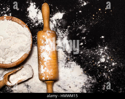 Flour and kitchen utensils on black background Stock Photo