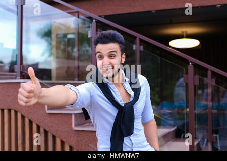 Arab guy excitedly shouting and showing gesture "Class!" Rejoices in success and proud of himself, photographer looks into camera and smiling, standin Stock Photo