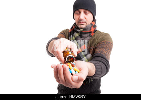 Exhausted male with flu taking medicines from glass bottle on white studio background Stock Photo