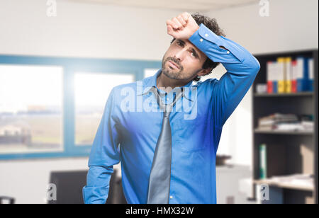 Sweating businessman due to hot climate Stock Photo