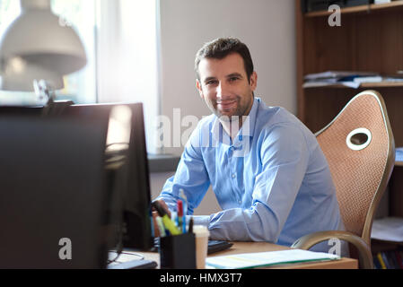 Smiling businessman at work in an office Stock Photo