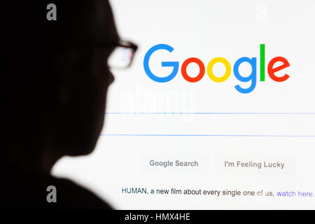 BATH, UK - SEPTEMBER 12, 2015: Close-up of the Google.com search homepage displayed on a LCD computer screen with the silhouette of a man's head out o Stock Photo