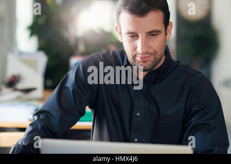 Businessman focused on work using a laptop in an office Stock Photo