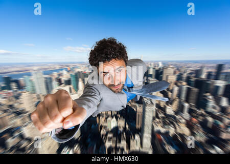 Businessman superhero flying above a city Stock Photo