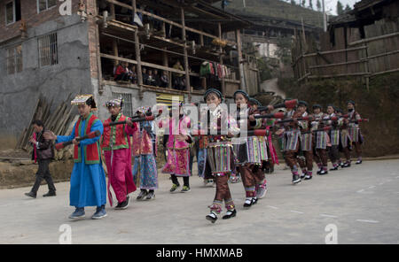 January 31, 2017 - China - Guizhou, CHINA-January 31 2017: (EDITORIAL USE ONLY. CHINA OUT) ..Yao people wearing traditional clothes of Yao ethnic minority group perform long drum dance in Congjiang County, southwest China's Guizhou Province, January 31st, 2017, marking the Spring Festival. In formal festive dress, with a red ribbon around the waist and white cloth wrapping legs, the dancers hang the more than 1 meter long drum. They sometimes jump into the air and make a sharp turn, sometimes pounce on like tigers. The long drum dance, a kind of representative dance of Yao People, entered the  Stock Photo