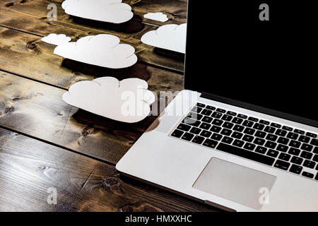 Cloud computing concept laptop close up with white clouds coming out of the computer indicating online storage and internet connection. Stock Photo
