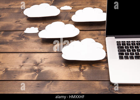 Cloud computing concept laptop close up with white clouds coming out of the computer indicating online storage and internet connection. Stock Photo