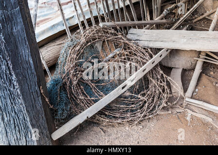 Roll of Rusty Barbed Wire and Dirty Nylon Net Stock Photo