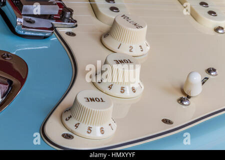 Close Up of a Fender Stratocaster electric guitar showing volume and tone controls , bridge saddle, pick-ups and pole pieces nad pick up selector Stock Photo