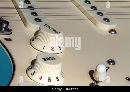 Close Up of a Fender Stratocaster Electric guitar showing volume and tone knobs and pick ups and pole pieces Stock Photo