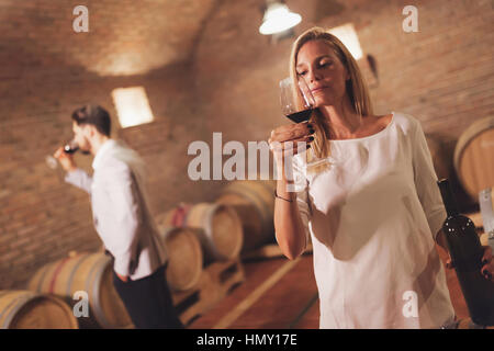 Wine loving couple tasting wines in winery cellar Stock Photo