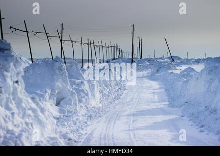 Winter road in the asbestos quarry along the transmission line Stock Photo