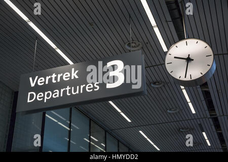 Sign to departures terminal and clock at airport Stock Photo