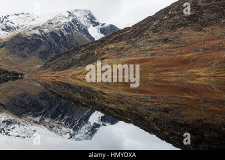 View looking West along Llyn Ogwen in the Snowdonia National Park in North Wales. The snow covered peaks of Snowdonia in the background. Stock Photo