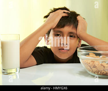 bored boy at breakfast isolated on yellow Stock Photo