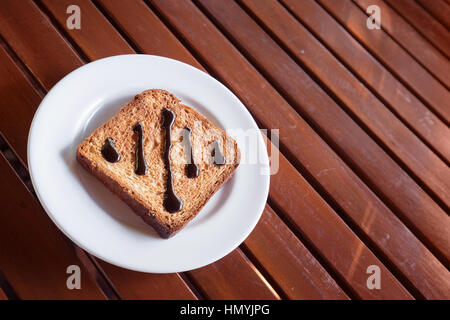 Chocolate Spread on Toast in white disk on wood table window light Stock Photo