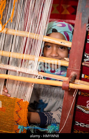 Morocco.  Young Amazigh Berber Girl Working at a Loom.  Ait Benhaddou Ksar, a World Heritage Site. Stock Photo