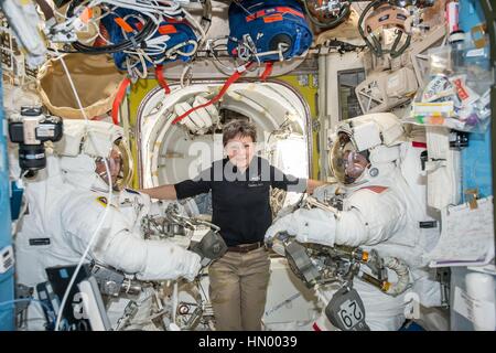 NASA Expedition 50 prime crew astronaut American Peggy Whitson (middle) floats inside the International Space Station Quest airlock with French astronaut Thomas Pesquet of the European Space Agency (left) and American astronaut Shane Kimbrough before their spacewalk January 13, 2017 in Earth orbit. Stock Photo