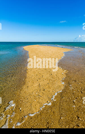 The rising tide swallows a small sand island. Stock Photo