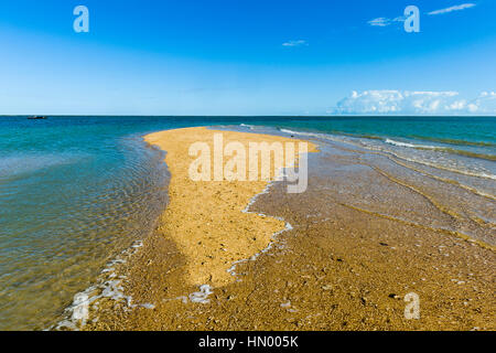 The rising tide swallows a small sand island. Stock Photo