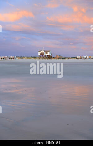 Evening mood, sunset on sandy beach with pile dwellings, Sankt Peter-Ording, Schleswig-Holstein Wadden Sea National Park Stock Photo