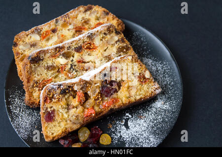 Homemade fruit bread on a black plate
