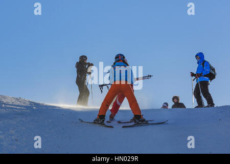 Woman ski instructor teaches tourists to slide down the ski slopes in Postavaru Mountain, Poiana Brasov, the most appreciated Romanian winter resort. Stock Photo