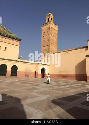 Motorcycle in courtyard of red Mosque in the medina of Marrakech, Morocco Stock Photo