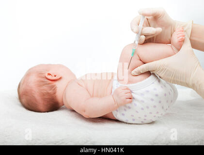 Close-up shot of pediatrician giving a three month baby girl  intramuscular injection in leg on white background Stock Photo
