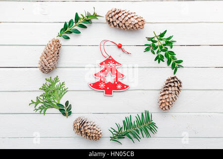 Wreath with natural decorations hanging on a white wooden background Stock Photo