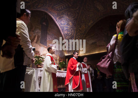 Jerusalem, Israel - October 29, 2013: Latin priest holds a mass in Nails of the Cross Chapel, the XI station of via Dolorosa, also known as Latin Calv Stock Photo