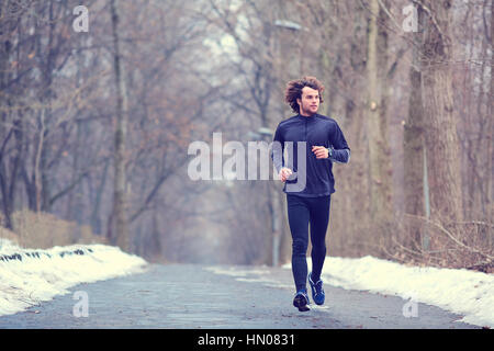 Young runner running in the park in spring, autumn on nature Stock Photo