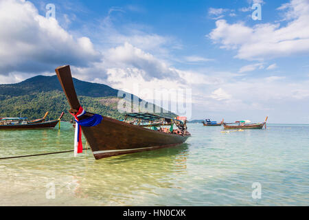 A low angle view of a traditional long tail on a beach in Koh Lipe island in the Andaman sea in south Thailand in Southeast Asia. A low angle view of a traditional long tail on a beach in Koh Lipe island in the Andaman sea in south Thailand in Southeast Asia.