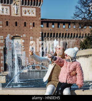 Rediscovering things everybody love in Milan. Full length portrait of smiling modern mother and child travellers in sunglasses near Sforza Castle in M Stock Photo