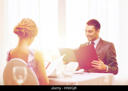 smiling young man looking at menu at restaurant Stock Photo