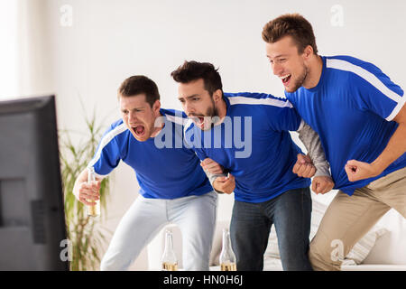 friends or football fans watching soccer at home Stock Photo