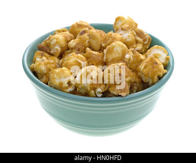 A green bowl filled with toffee caramel popcorn with nuts isolated on a white background. Stock Photo
