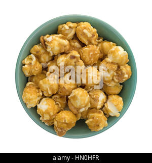 Top view of a green bowl filled with toffee caramel popcorn with nuts isolated on a white background. Stock Photo