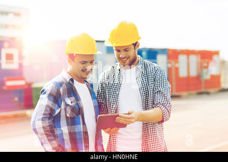 two smiling builders in hardhats with tablet pc Stock Photo