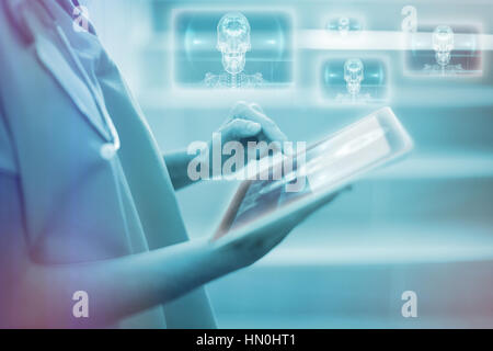 Skull and brain graphic on black against female surgeon using digital tablet 3d Stock Photo