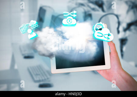 Feminine hand holding tablet against computers and headsets Stock Photo