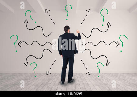 Businessman in suit writing with marker against big room with white wall Stock Photo