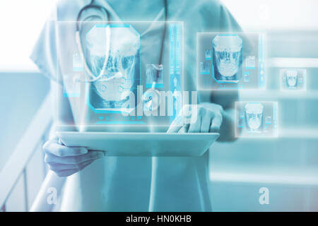 Digitally generated image of human skull against female surgeon using digital tablet 3d Stock Photo