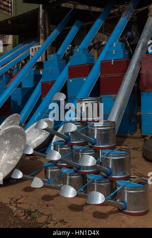 A selection of stainless steel watering cans and containers with vibrant blue and red accents Stock Photo