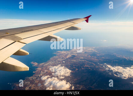 Airplane flying above beach sea blue island - Travel Concept Stock Photo